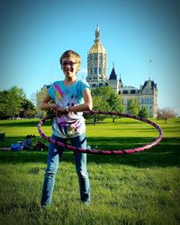 Full length of young woman in lawn against clear sky