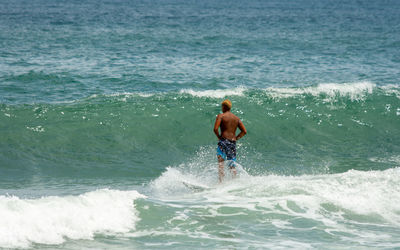 Full length of shirtless man in sea