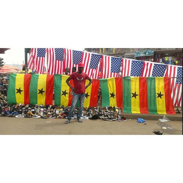 large group of people, men, person, clear sky, lifestyles, flag, leisure activity, copy space, walking, multi colored, national flag, patriotism, transportation, mixed age range, medium group of people, street, day, crowd, in a row