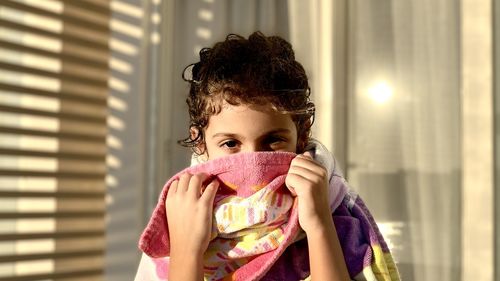 Portrait of young girl covering nose and mouth 