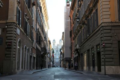 Empty road amidst buildings in city