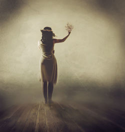 Rear view of woman standing on pier during foggy weather