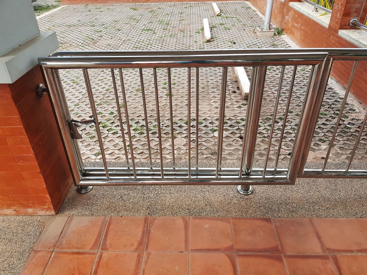 HIGH ANGLE VIEW OF METAL RAILING ON FOOTPATH BY BUILDING