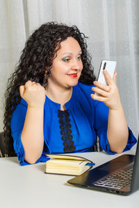 Young woman using mobile phone on table