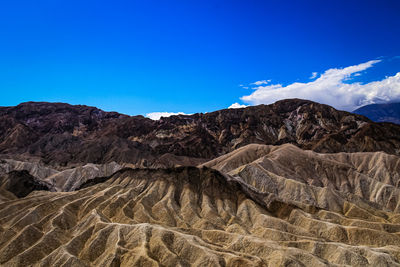 Scenic view of mountain range against blue sky