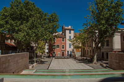 Quiet square with trees and buildings at the city center of nimes, in the french provence.