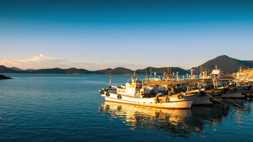 Boats moored in sea against sky