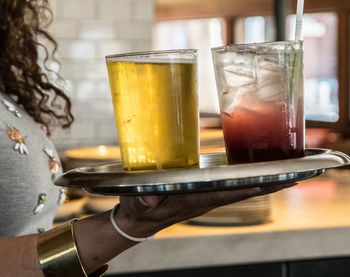 Close-up of hand holding beer glass on table