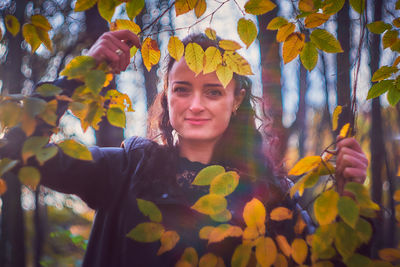 Portrait of young woman with autumn leaves