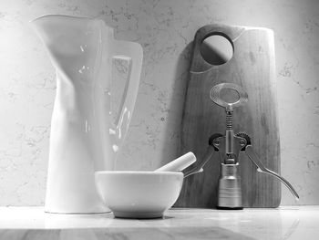 Close-up of mortar and pestle by jug on table