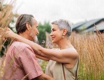 Side view of couple kissing on field