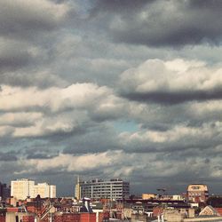 View of cityscape against cloudy sky