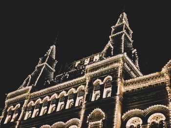 Low angle view of illuminated building against sky at night