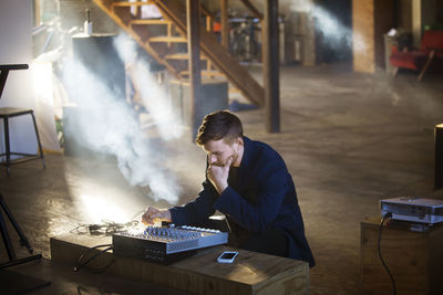 Man concentrating on audio equipment at home