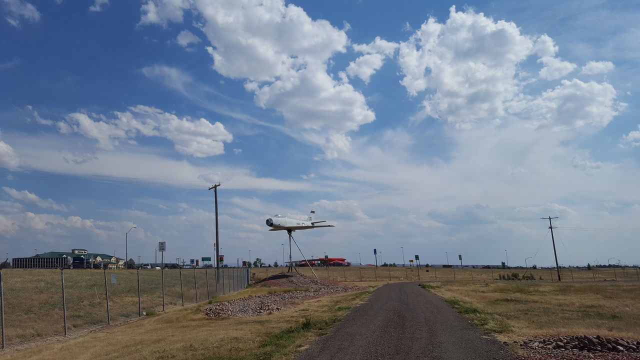 sky, street light, cloud, cloud - sky, tranquil scene, day, travel destinations, solitude, tranquility, outdoors, scenics, cumulus cloud, tourism, rural scene, non-urban scene, windmill, the way forward, cloudscape, countryside, remote, footpath, development, country road