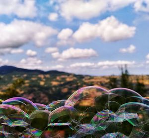 Close-up of bubbles against cloudy sky