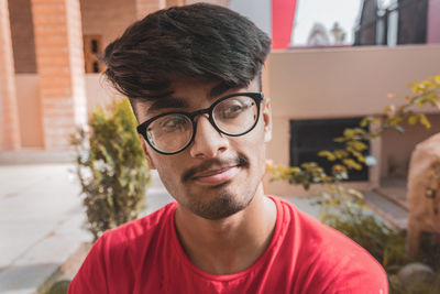 Close-up of young man wearing eyeglasses looking away