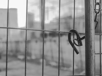 Close-up of metal railing against fence