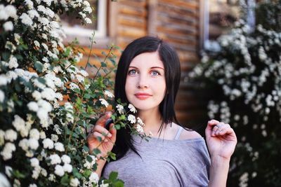 Portrait of young woman against plants