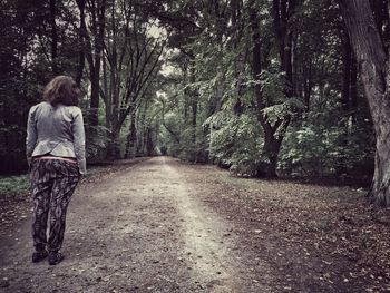 Rear view of woman walking on road