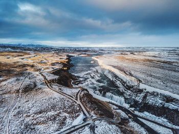 Scenic view of snow covered land against sky