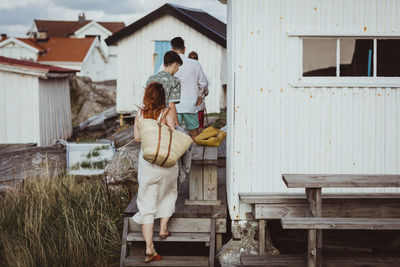 Rear view of couple standing outside house