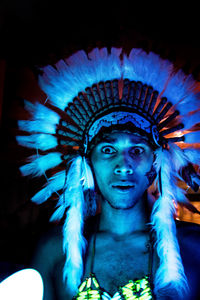 Portrait of man wearing headdress in darkroom