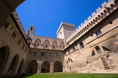 Low angle view of historical building against clear blue sky