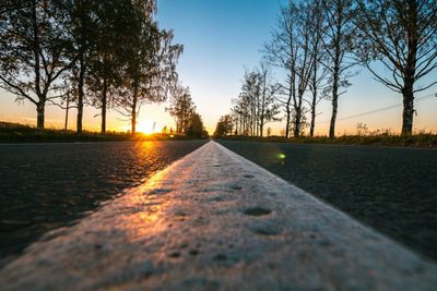 Surface level of road against sky during sunset