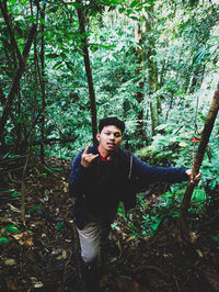 Portrait of young man standing in forest
