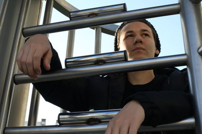 Man looking through metal bars