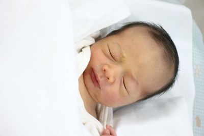 Close-up of baby girl sleeping on bed