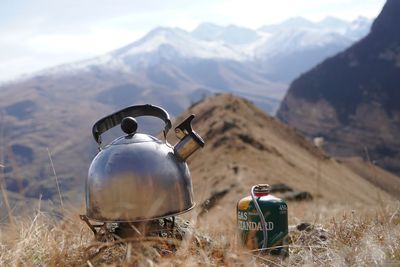 Electric lamp on field by mountains against sky