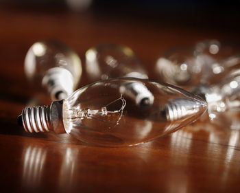 Close-up of light bulbs on wooden table