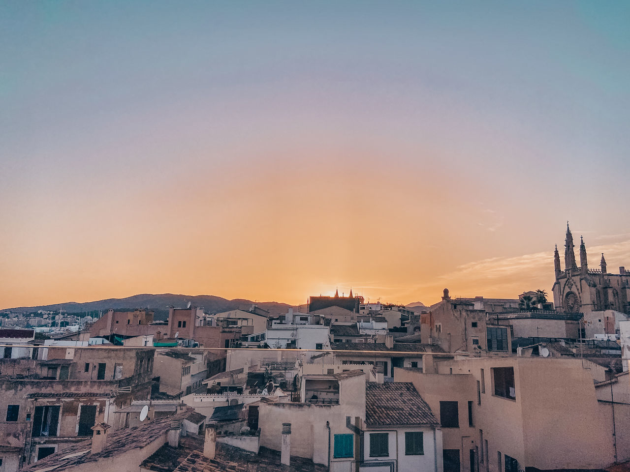 HIGH ANGLE SHOT OF TOWNSCAPE AGAINST ORANGE SKY