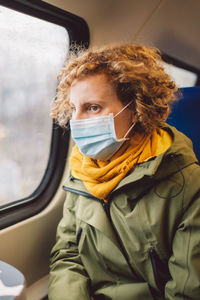 Woman wearing mask sitting in car