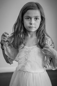 Girl standing against wall at home