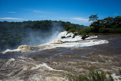 Scenic view of waterfall against sky