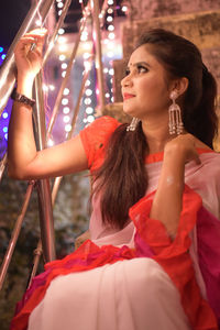 Young woman holding illuminated string light at night