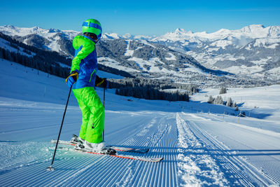 Low section of woman skiing on snow covered mountain