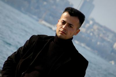 Portrait of young man standing against sea