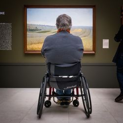 Rear view of man sitting on window