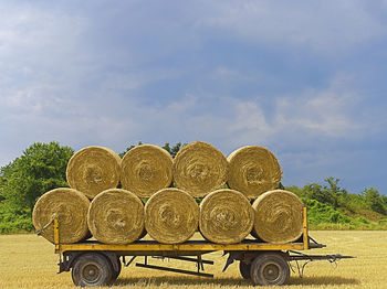 Hay bales on field against sky