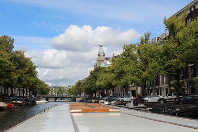 Canal amidst buildings against sky in city