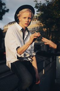 Full length of young man looking away while standing outdoors