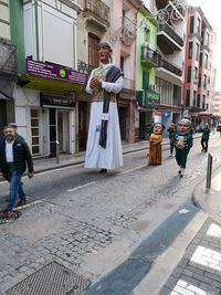 People standing on street amidst buildings in city