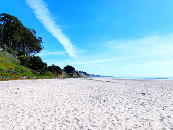 Scenic view of beach against blue sky