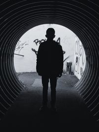 Rear view of man standing in tunnel