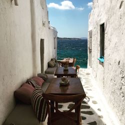 High angle view of chairs and tables arranged at alley against sea