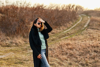 Young woman wearing hat standing on field